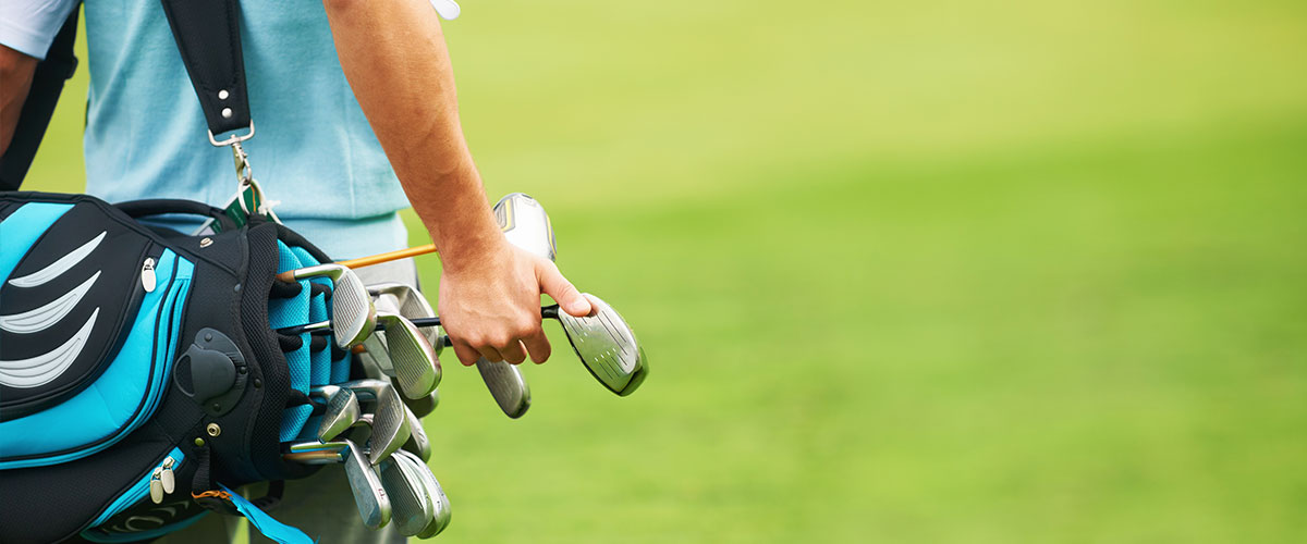 man walking with golf clubs