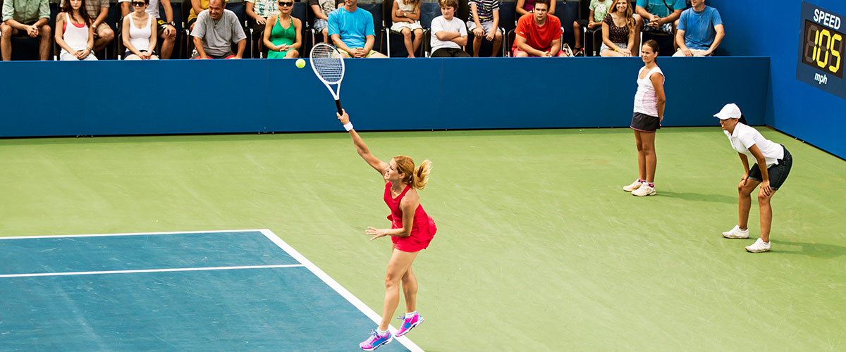 woman serving tennis ball